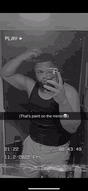 a black and white photo of a man taking a selfie with a caption that says " that 's paint on the mirror "