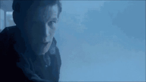 a woman with a surprised look on her face is sitting next to a man in a suit .