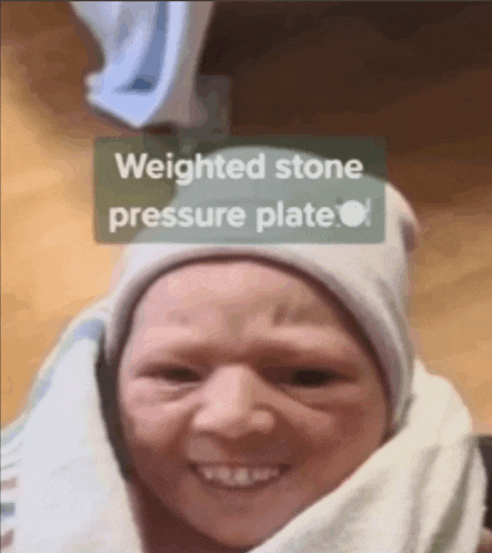 a baby wrapped in a blanket with the words weighted stone pressure plate above it