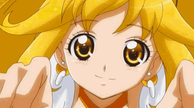 a close up of a girl with yellow hair making a funny face