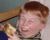 a young boy with red hair is making a funny face while holding a banana .