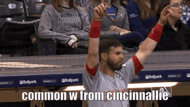 a baseball player is raising his arms in the air with the caption common w from cincinnati