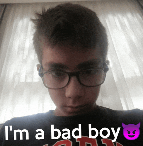 a young boy wearing glasses and a shirt that says i 'm a bad boy