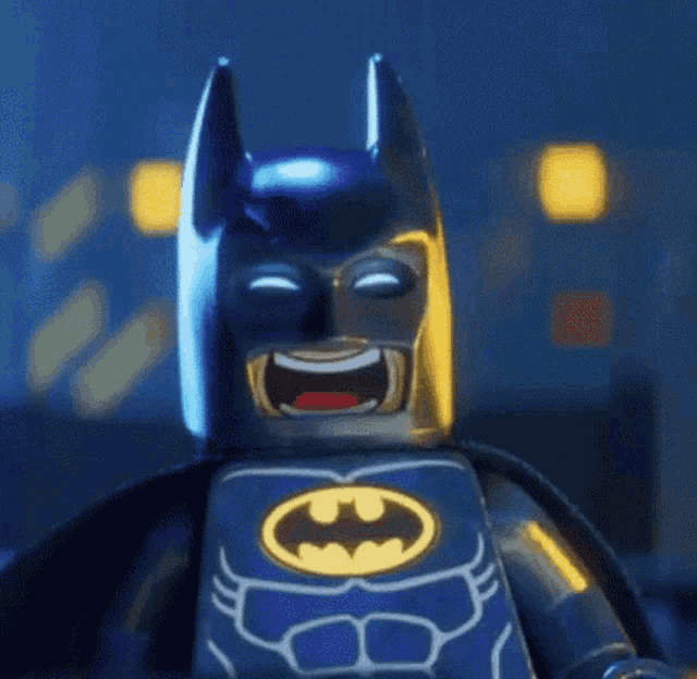 a close up of a lego batman laughing with his eyes closed and his mouth open .