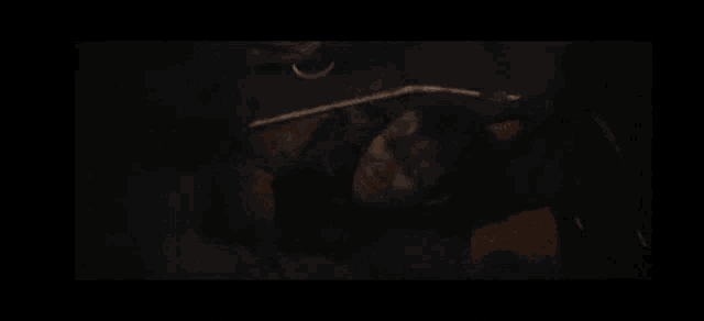 a man in a batman costume is standing next to a woman in a dark room .