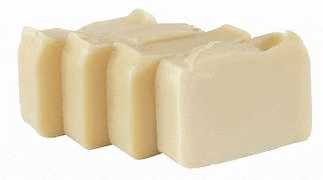 three pieces of white soap are stacked on top of each other on a white surface .