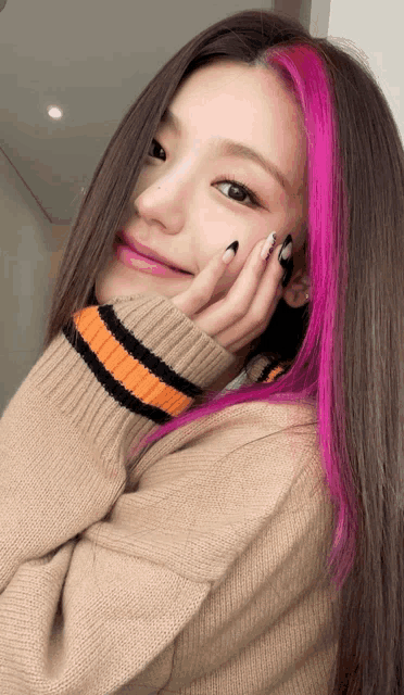 a woman with pink hair is wearing a sweater