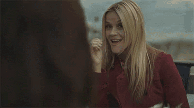 a woman is smiling and talking to another woman .