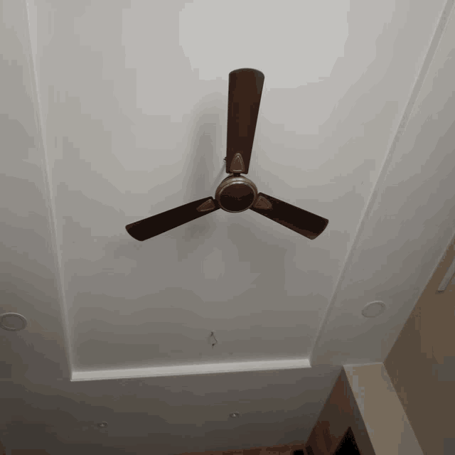 a ceiling fan with three blades is hanging from a white ceiling