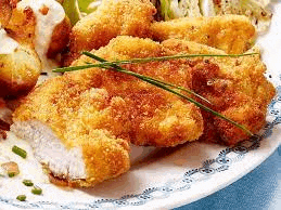 a close up of a plate of food with fried chicken , potatoes , and vegetables .