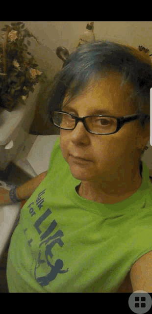 a woman with blue hair is wearing glasses and a green shirt that says hulk for life