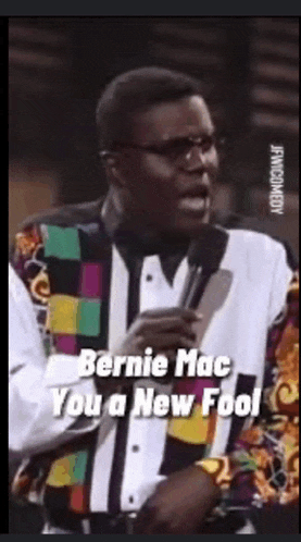 a man speaking into a microphone with the words bernie mac you a new fool on the bottom