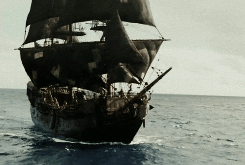 a large ship is floating in the ocean with a black sail