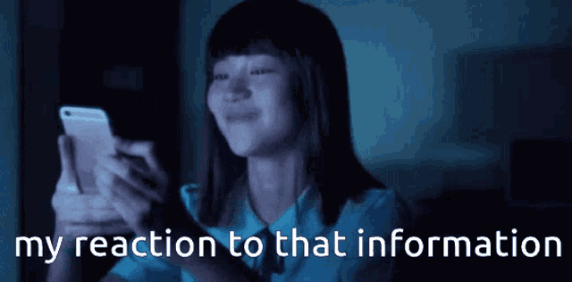 a woman is looking at her cell phone with the words my reaction to that information written below her