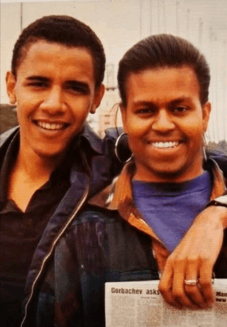 two young men are posing for a picture and one of them is holding a newspaper that says gorbachev asks