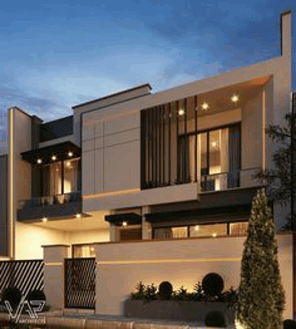 a modern house with a lot of windows and a fence in front of it at night .