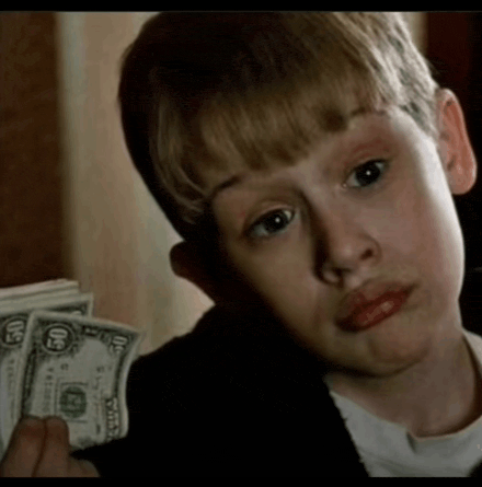 a young boy is holding a stack of 20 dollar bills in his hand