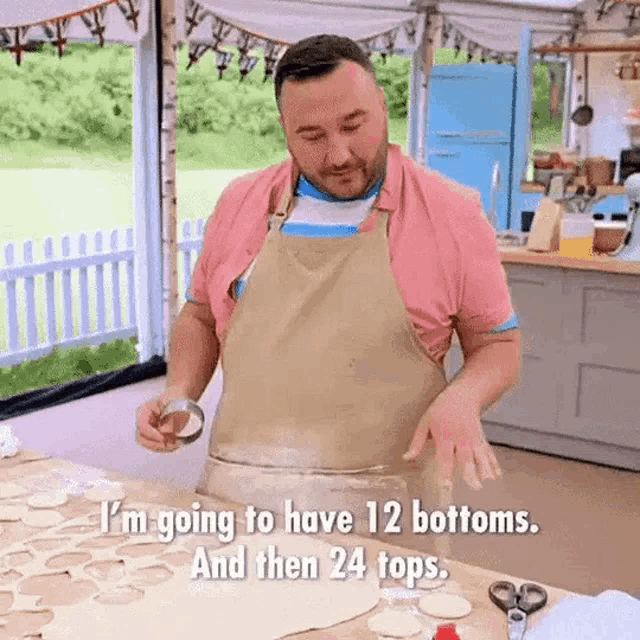 a man in an apron is standing in front of a table with a bowl of dough .