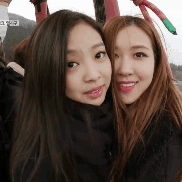 two young women are posing for a picture together while riding a hot air balloon .