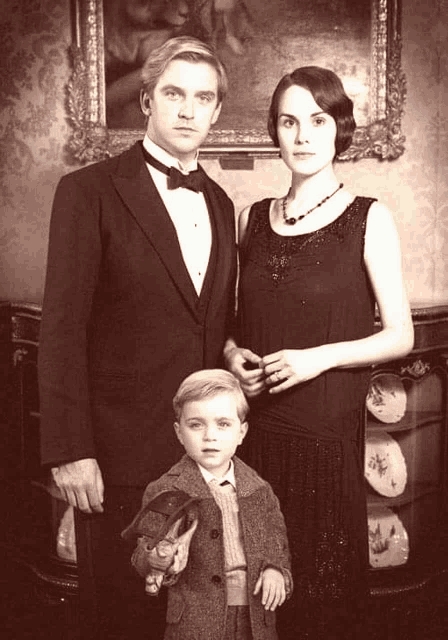 a man in a tuxedo stands next to a woman and a boy