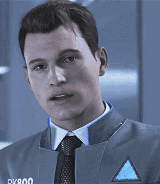 a man is wearing a suit and tie and has a triangle on his chest .