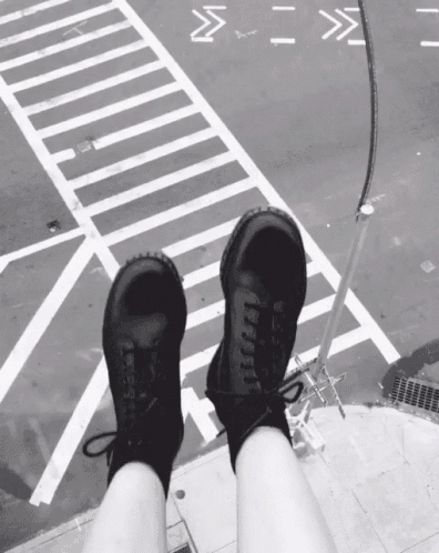 a black and white photo of a person 's feet in front of a crosswalk with the letters m and s on it