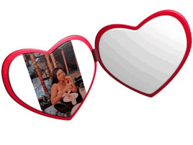 a heart shaped mirror has a picture of a woman in the reflection