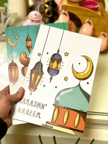 a person is holding a ramadan kareem card