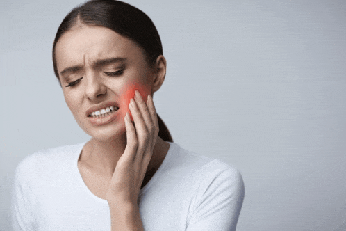 a woman has a toothache and is holding her face