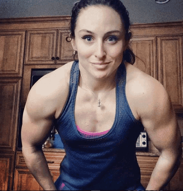 a woman in a blue tank top with a necklace on her neck