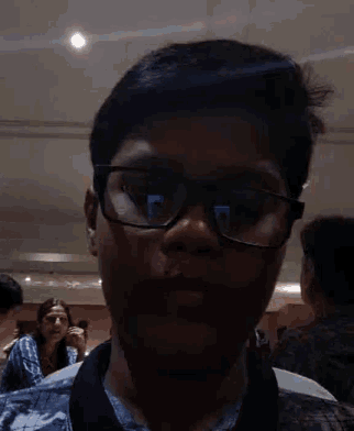 a young man wearing glasses is taking a selfie