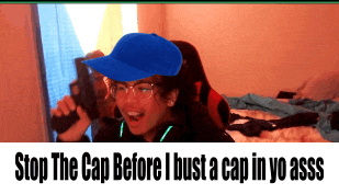 a woman wearing a blue hat and glasses is laying on a bed