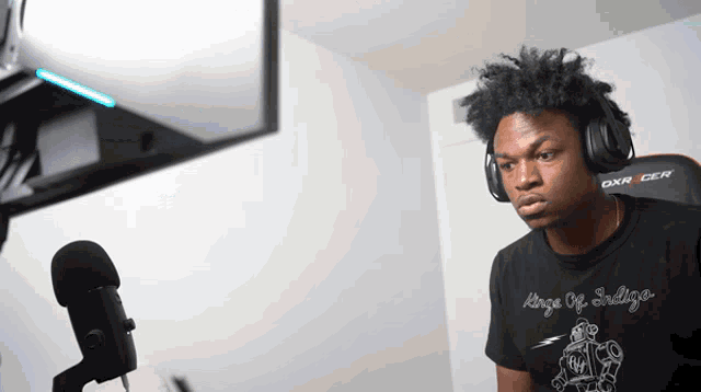 a man wearing headphones and a black shirt that says kings of sadness