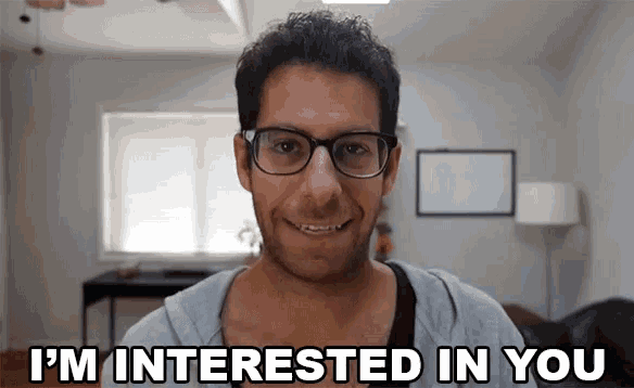 a man wearing glasses is smiling and says i 'm interested in you