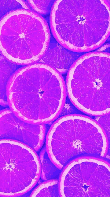 purple oranges are stacked on top of each other on a purple background