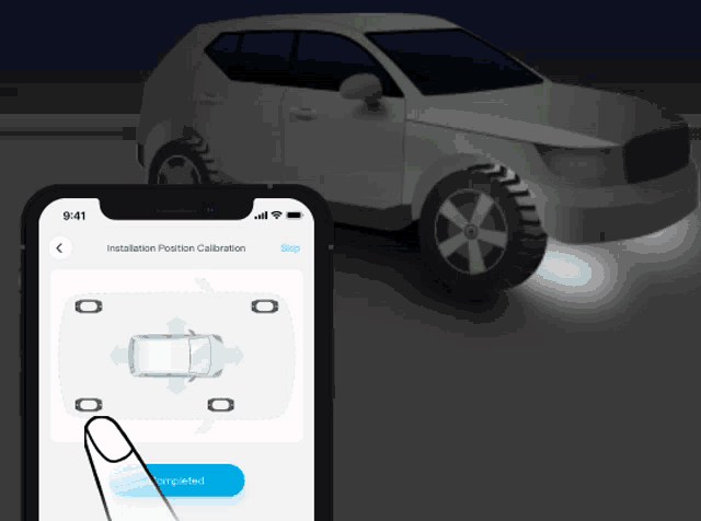 a phone screen shows a car being calibrated and a button that says completed