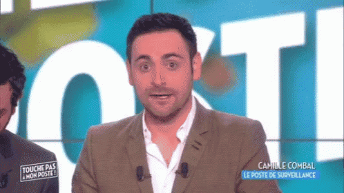 a man in a suit is standing in front of a sign that says " touche pas mon poste "