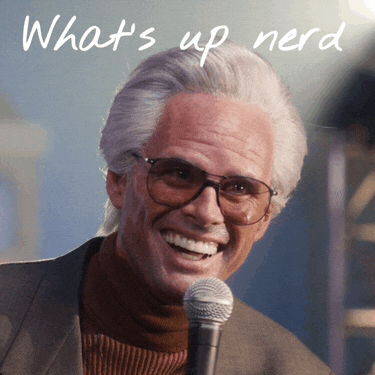 a man with glasses is smiling and holding a microphone with the words what 's up nerd below him