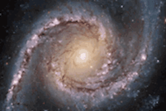 a spiral galaxy with a yellow center is surrounded by a dark background