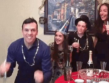 a group of people are celebrating new year 's eve in front of a painting with a sign that says happy new year