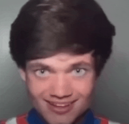 a close up of a man 's face with a red , white and blue shirt .