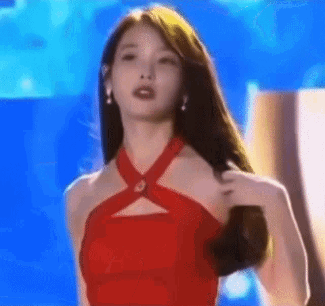 a woman in a red dress is dancing on stage .