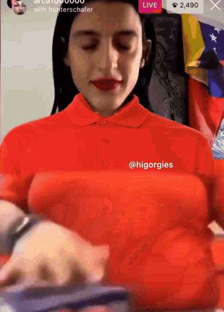 a woman wearing a red shirt with the hashtag @hiorgies