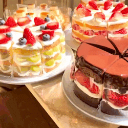 three cakes with strawberries and blueberries on them are sitting on a table
