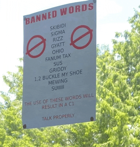 a sign that says " banned words " hangs from a tree