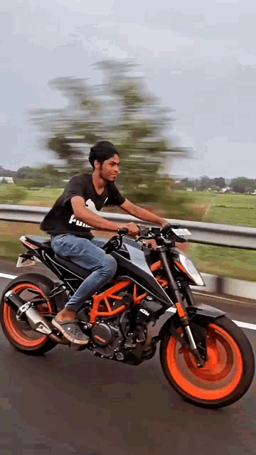 a man riding a motorcycle on a highway with a black shirt that says ' i am ' on it