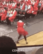 a woman in a red dress is dancing on a stage in front of a crowd at a graduation ceremony .