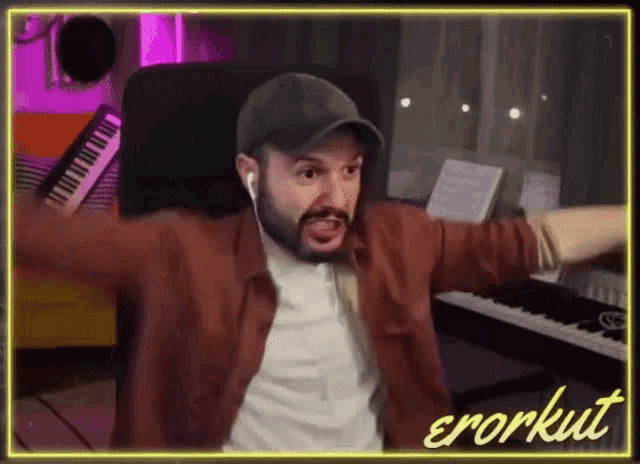 a man in a hat is sitting in front of a piano with his arms outstretched and the word errorkut written on the bottom