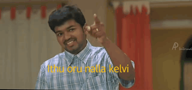 a man in a plaid shirt is pointing at the camera with the words " ithu oru nilla kelvi " written in yellow