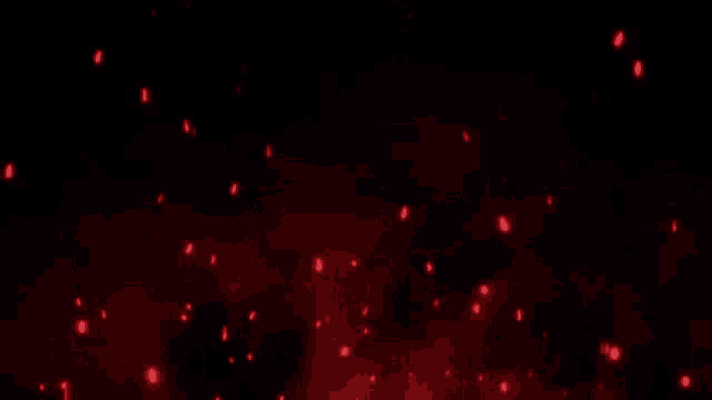 a bunch of red sparks are flying in the air on a black background .